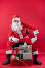 
Portrait von einem verkleideten Weihnachtsmann mit Geschenk, isoliert auf roten Hintergrund im...