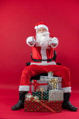 
Portrait von einem verkleideten Weihnachtsmann mit Geschenk, isoliert auf roten Hintergrund im...