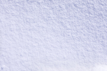 Smooth texture of fresh fluffy snow after a snowfall with shiny sparks of snowflakes, snowy white background