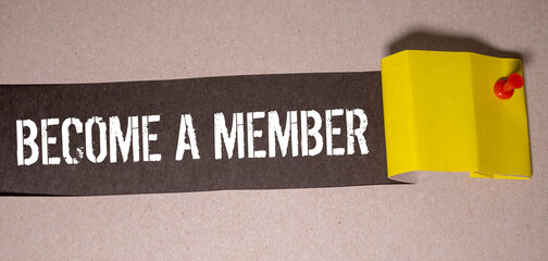 On a light pink background - a craft envelope. It has a white sheet of paper that says BECOME A MEMBER.