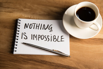 The inscription on paper nothing is impossible and a cup of coffee
