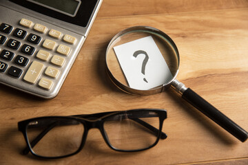 Question mark, calculator and magnifier