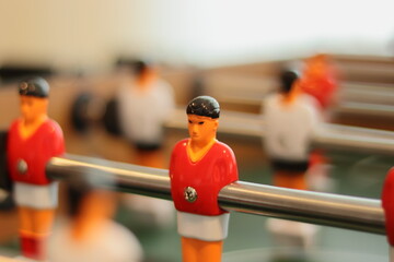 Foosball doll attached to the metal bar, with the rest of the players out of focus. Selective focus.