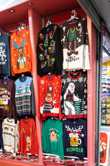 A temporary seasonal display of ugly Christmas sweaters at a retail store .