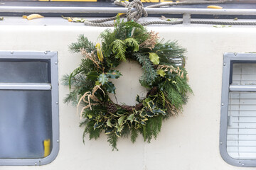 a wreath of fir branches adorned with red hypericum berries and pine cones decorate the white door...