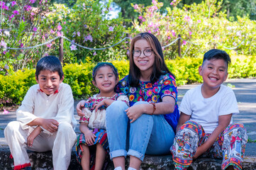 Familia Latina.  Retrato de una familia feliz al aire libre. Hermana mayor con sus hermanos sonrien...