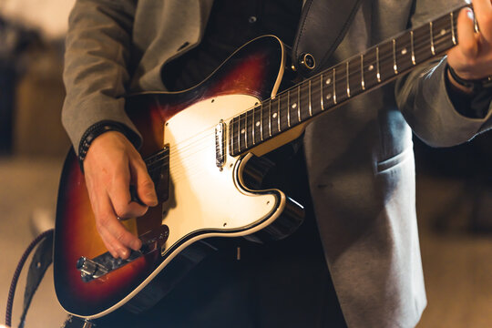 closeup shot of a guitarist playing on a bass guitar, music band concept studio. High quality photo