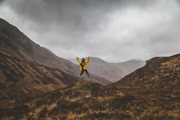 person jumping in a landscape, mountain range in scotland