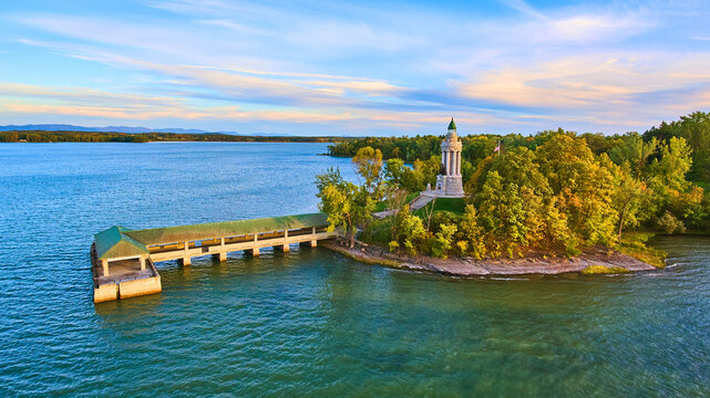 Fall coastline aerial next to large dock and cement memorial lighthouse tower