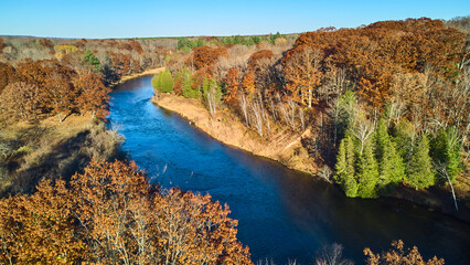 Warm colored forest aerial with large blue river