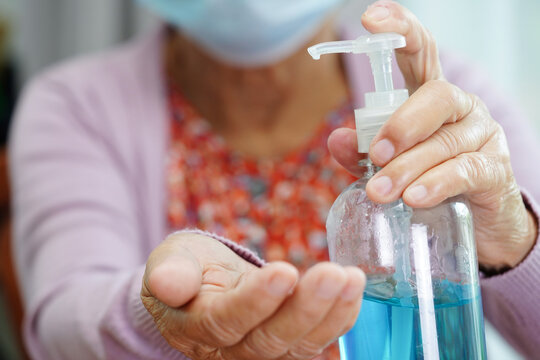 Asian senior woman press blue alcohol sanitizer gel for washing hand protect infection coronavirus.