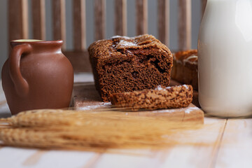 Homemade rye bread with raisins, milk, eggs and wheat ears on the table. Space for text.