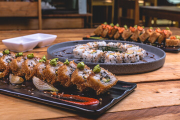 Delicioso plato de sushi empanizado bañado en salsa inglesa sobre una mesa