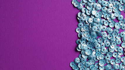 Many silver sequins on purple background, flat lay. Space for text