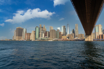 View of lower Manhattan and its skyscrapers from under the Brooklyn Bridge