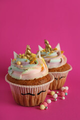 Cute sweet unicorn cupcakes on pink background