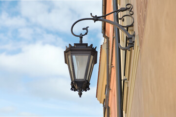 Fototapeta na wymiar Beautiful vintage street lamp hanging on wall of building