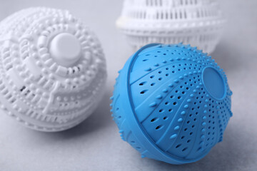 Dryer balls for washing machine on light grey table, closeup. Laundry detergent substitute
