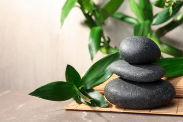 Fotobehang Zen Stacked spa stones and bamboo on mat. Space for text  © New Africa