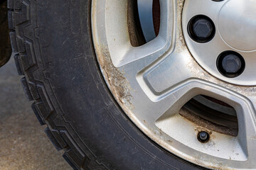 Old, corroded aluminum wheel on vehicle. Automobile maintenance repair and car care concept.