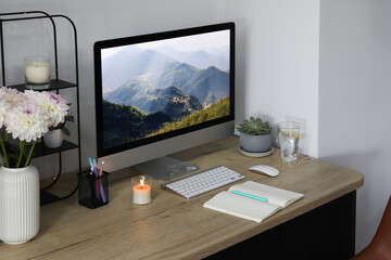 Comfortable workplace with modern computer, decor and office supplies on wooden table indoors