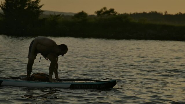 Man Falls Off Paddle Board Slomo Losing Balance Splashing Into Water Sunset.