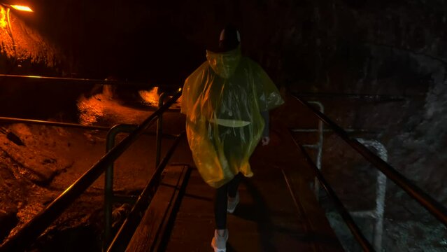 Mauna Loa volcano in Hawaii, woman walking into dark tunnel