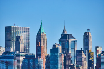 Fototapeta na wymiar New York City skyline detail of tops of skyscrapers with blue sky