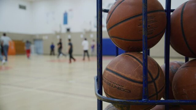 Several basketballs in a cage during gym class high school