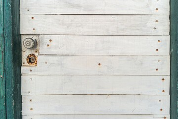 Grunge old white and green door with lock.