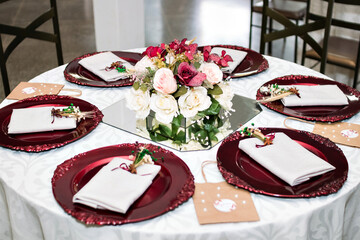 a table decorated with plates, bowls and a vase with flowers in the center