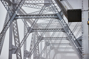 Inner top of old steel bridge fading in foggy morning