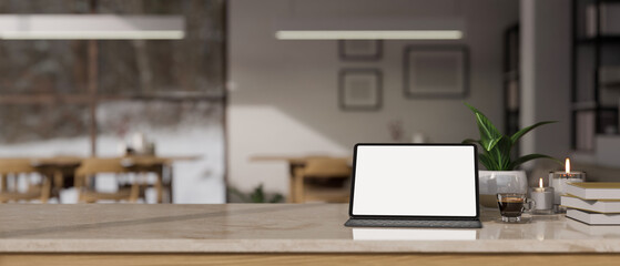Tabletop with tablet mockup and copy space against blurred background of co-working space