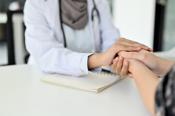 Close-up image, A doctor reassuring a patient by gently holding the patient hands