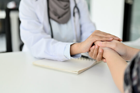 Close-up image, A doctor reassuring a patient by gently holding the patient hands