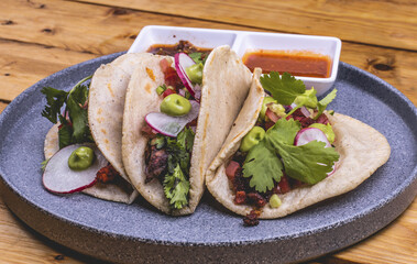 Taco de mariscos acompañado de ensalada, queso, y salsas