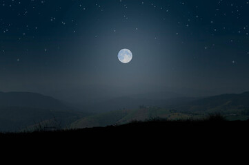 Fototapeta na wymiar Romantic white full moon over the mountains from rock cliff view point