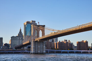 Obraz premium Brooklyn Bridge in New York City with city skyline in background along river