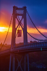 Stunning golden sunrise over American Bridge highlighting American Flag hanging