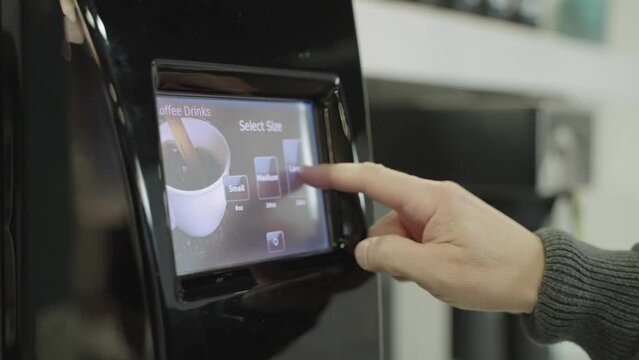 Anonymous person's hand selecting type of coffee on machine touch screen panel, slow motion
