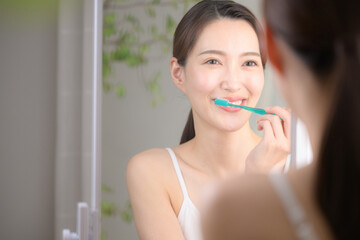 笑顔で歯ブラシをする美しい女性
