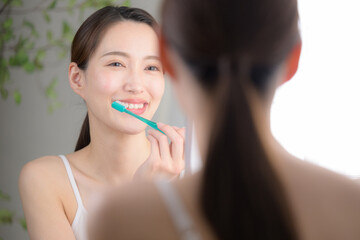 笑顔で歯ブラシをする美しい女性