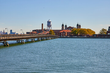 View of Ellis Island from New Jersey coast with bridge leading to island - Powered by Adobe