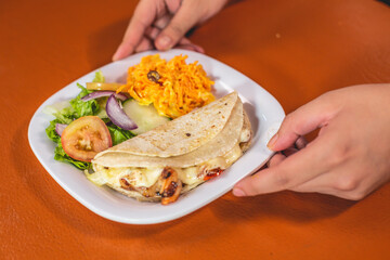 Taco de mariscos acompañado de ensalada, queso, y salsas