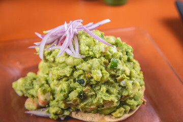 Tostada de guacamole con cebolla morada y mariscos