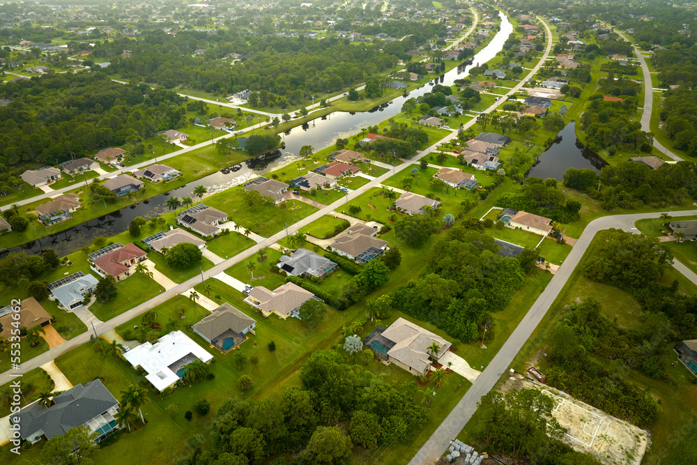 Wall mural Aerial view of small town America suburban landscape with private homes between green palm trees in Florida quiet residential area - Wall murals