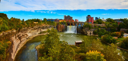 Beautiful Rochester city skyline from river canyon with huge waterfall over cliffs