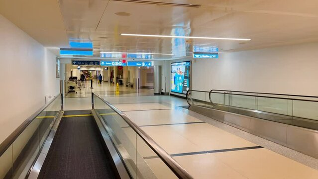 Slow pullback shot while standing on a moving walkway in CLT airport while it is empty with no people visible in the frame.