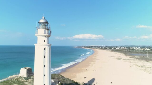 Aerial reveal view of the Trafalgar lighthouse on the beach Los Canos de Meca 