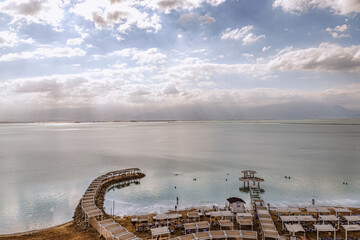 top view of the beach with sun loungers and a canopy from the sun. people swim in the sea, summer, vacation, sea, dead sea Israel, 